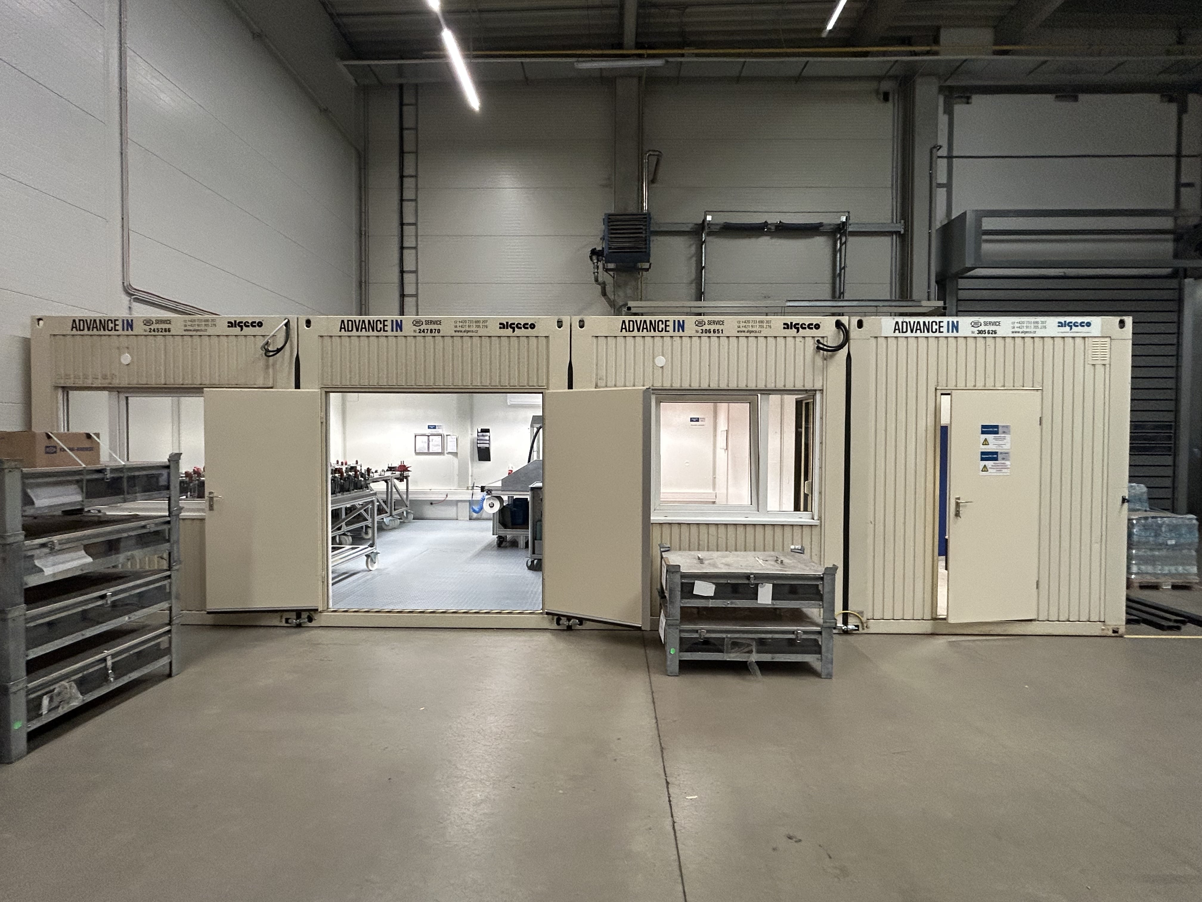 Modulární kontejnery IN26 (ADVANCE IN) instalované uvnitř průmyslové haly – propojená DUO sestava se vstupem a oknem, zázemí technologického pracoviště, Brno CT Park