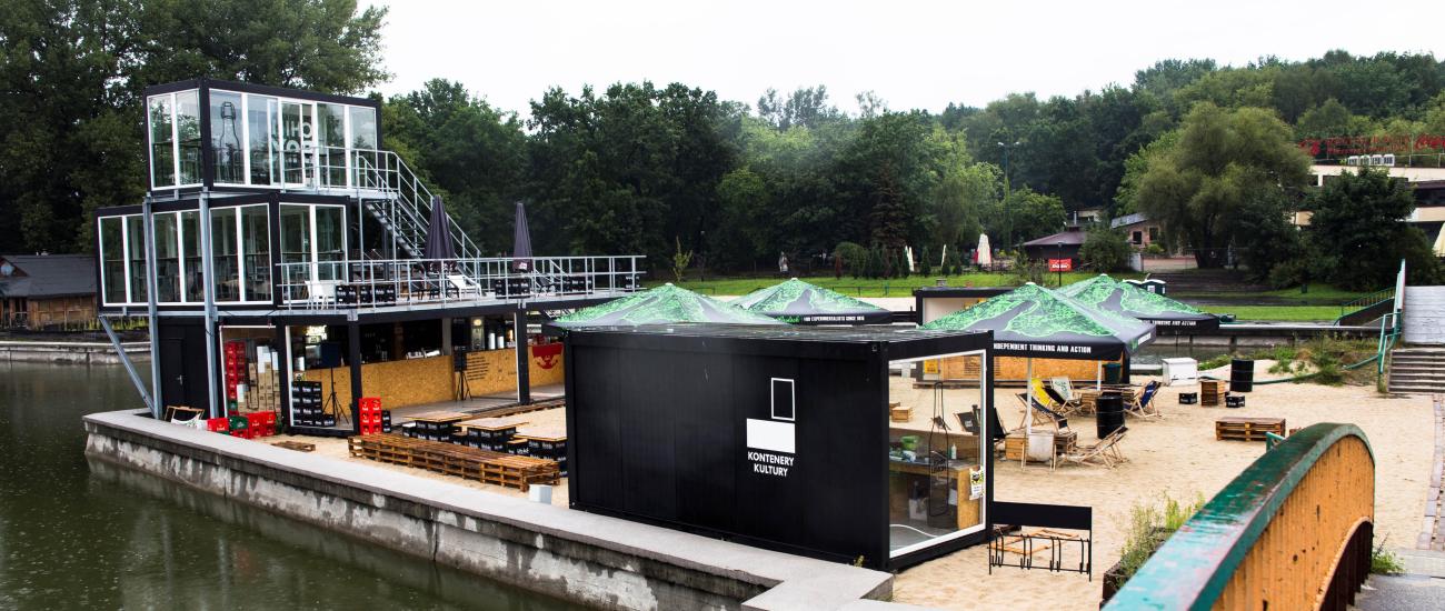 Vícepodlažní gastro kontejnery Vícepodlažní gastro kontejnery s velkou plochou na posezení pro zákazníky. Umístěno v přírodě u vody.