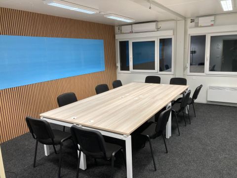 Zasedací místnost s akustickými panely a tabulí – modulární kanceláře SMART Zasedací místnost v modulární kanceláři SMART – akustické lamelové panely a velká popisovatelná tabule, Kopřivnice